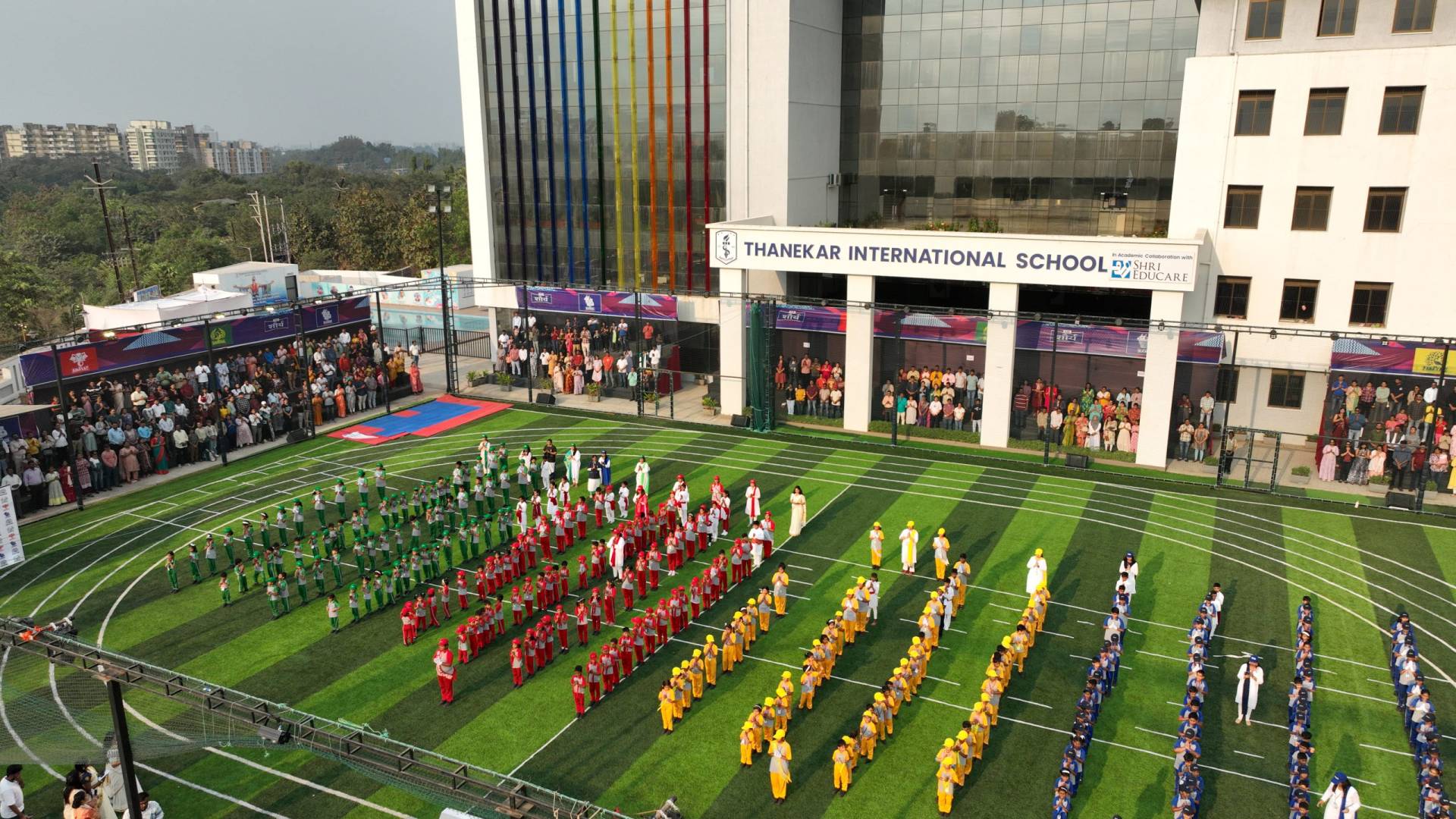 A tablet rests on top of a stack of books in an empty classroom, illustrating modern education.